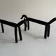 Pair of animal-shaped wrought iron and hammered fire dogs in primitive brutalist style.
