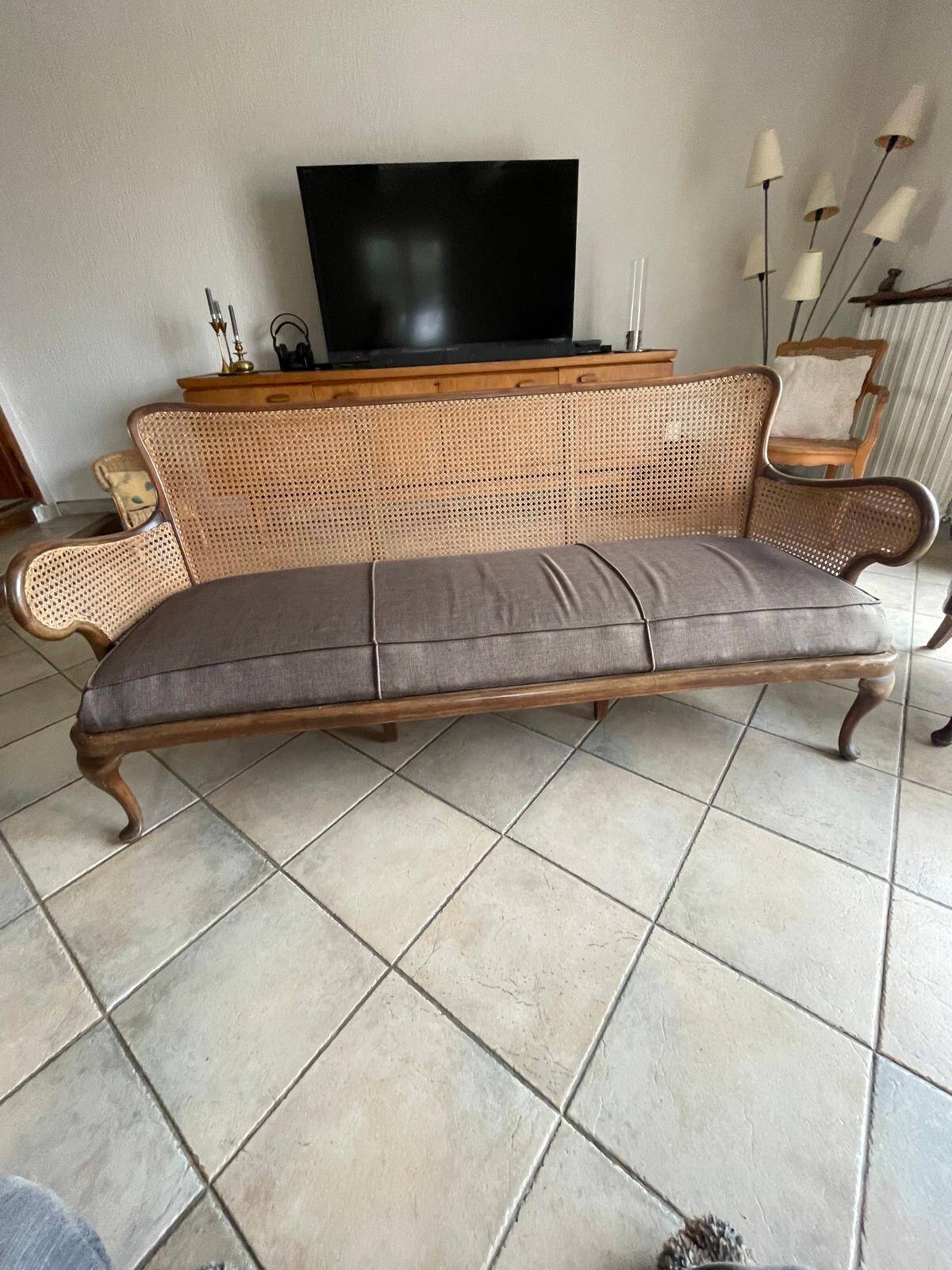 Sofa with backrest and cane armrests