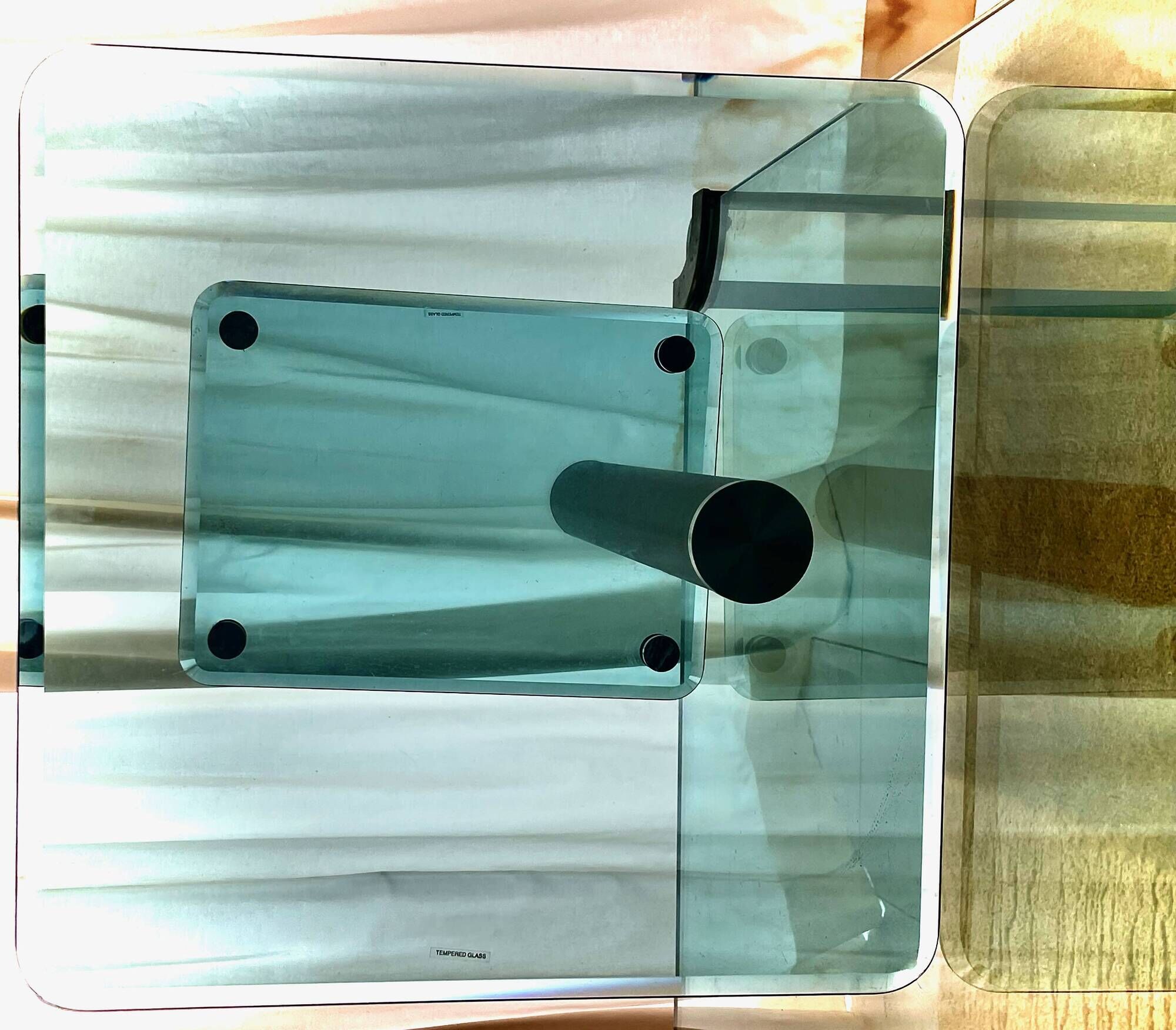 Contemporary square side table in glass with a metallic central column.