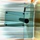 Contemporary square side table in glass with a metallic central column.