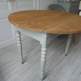Walnut table with raised flaps, base on verdigris casters.