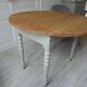 Walnut table with raised flaps, base on verdigris casters.