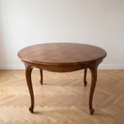 Round extendable dining table in Louis XV style made of wood.