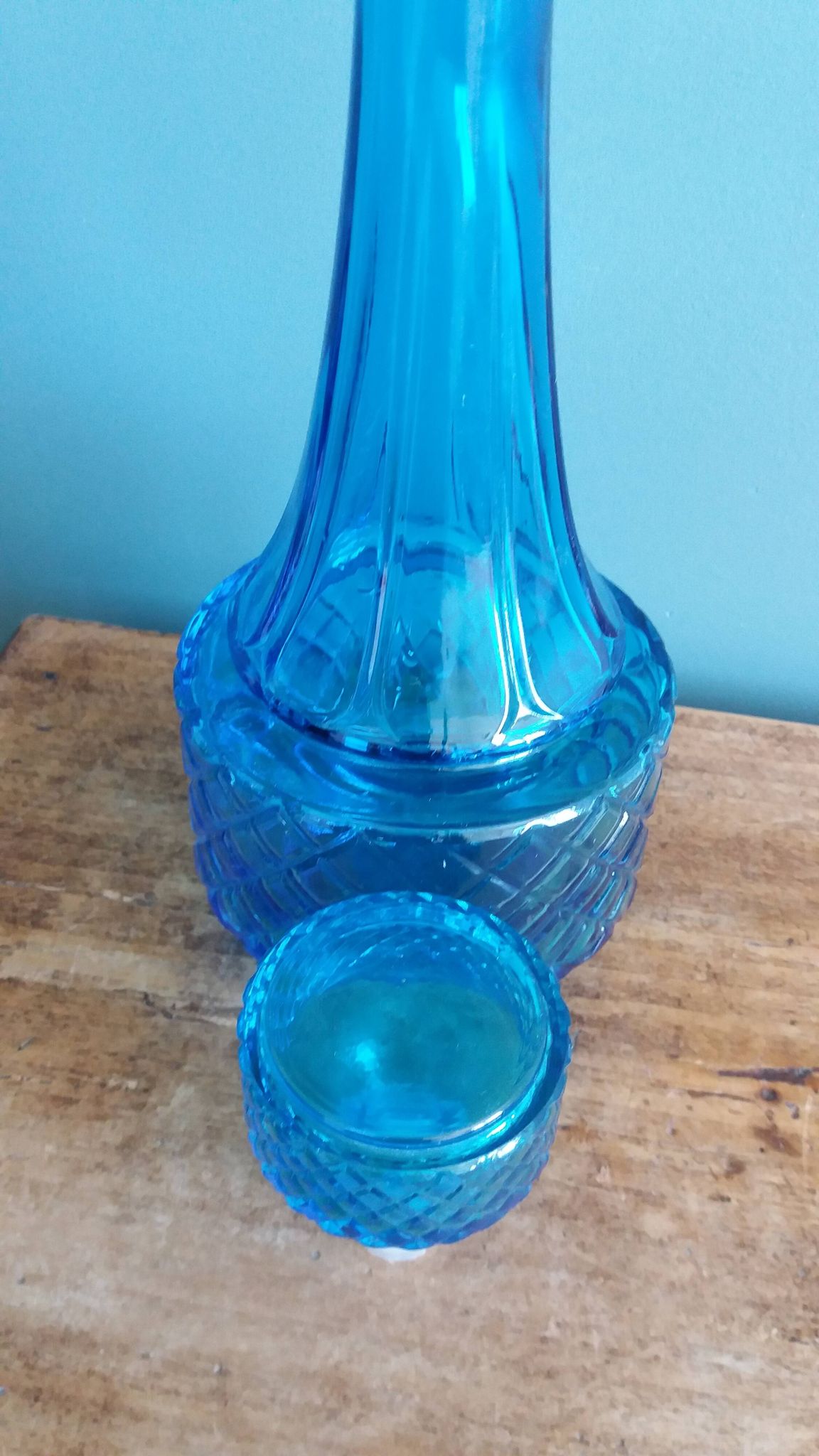 Turquoise glass carafe bottle with a stopper.