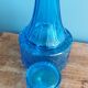 Turquoise glass carafe bottle with a stopper.