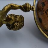 Cherub or putti carrying a globe