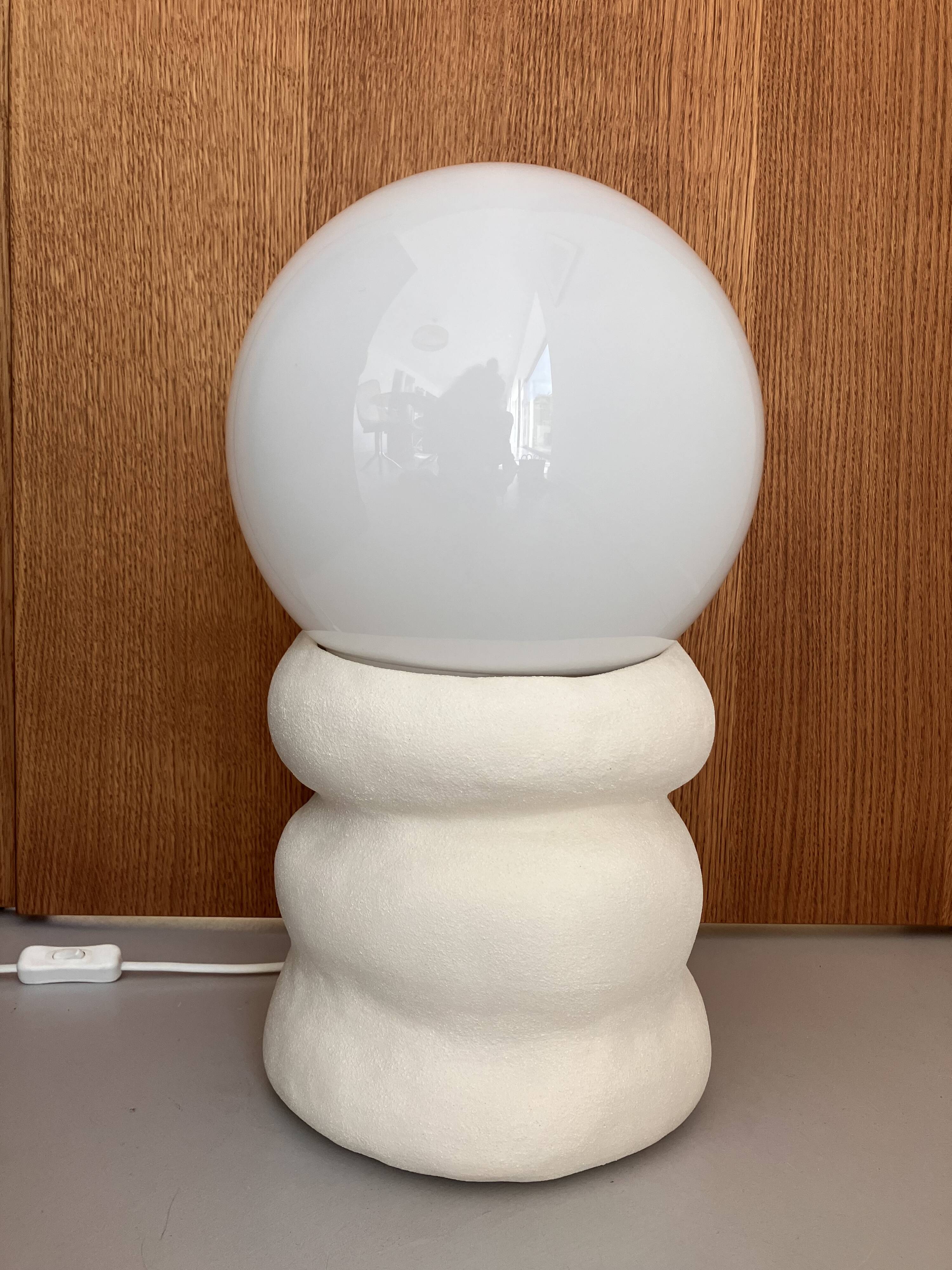 Large table lamp in off-white ceramic with an organic globe shape.