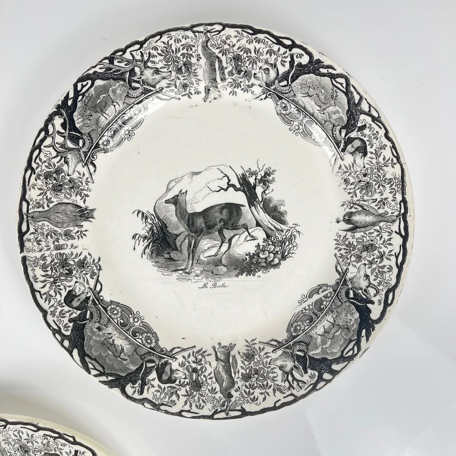Set of three antique Sarreguemines U&C plates with hunting decoration from 1850 - 19th century black earthenware featuring a doe, chamois, and fox.