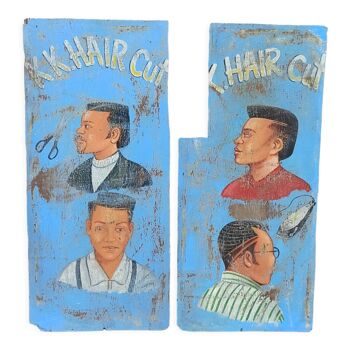 Old painted sign of African hairdresser in wood