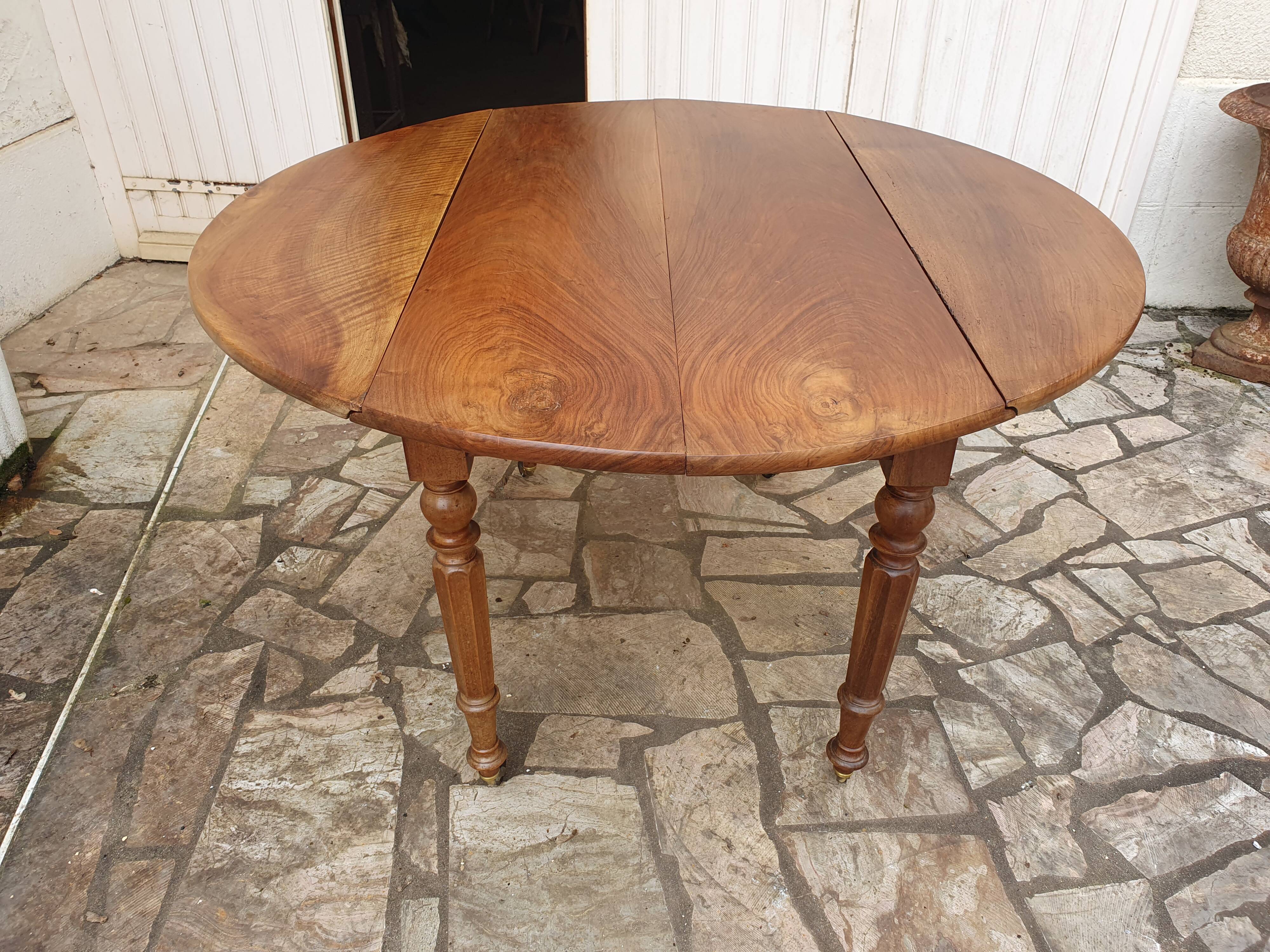 Round extending table in solid walnut, 19th century