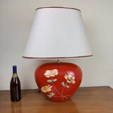 large vintage ceramic lamp with flower decorations on a red background circa 1980