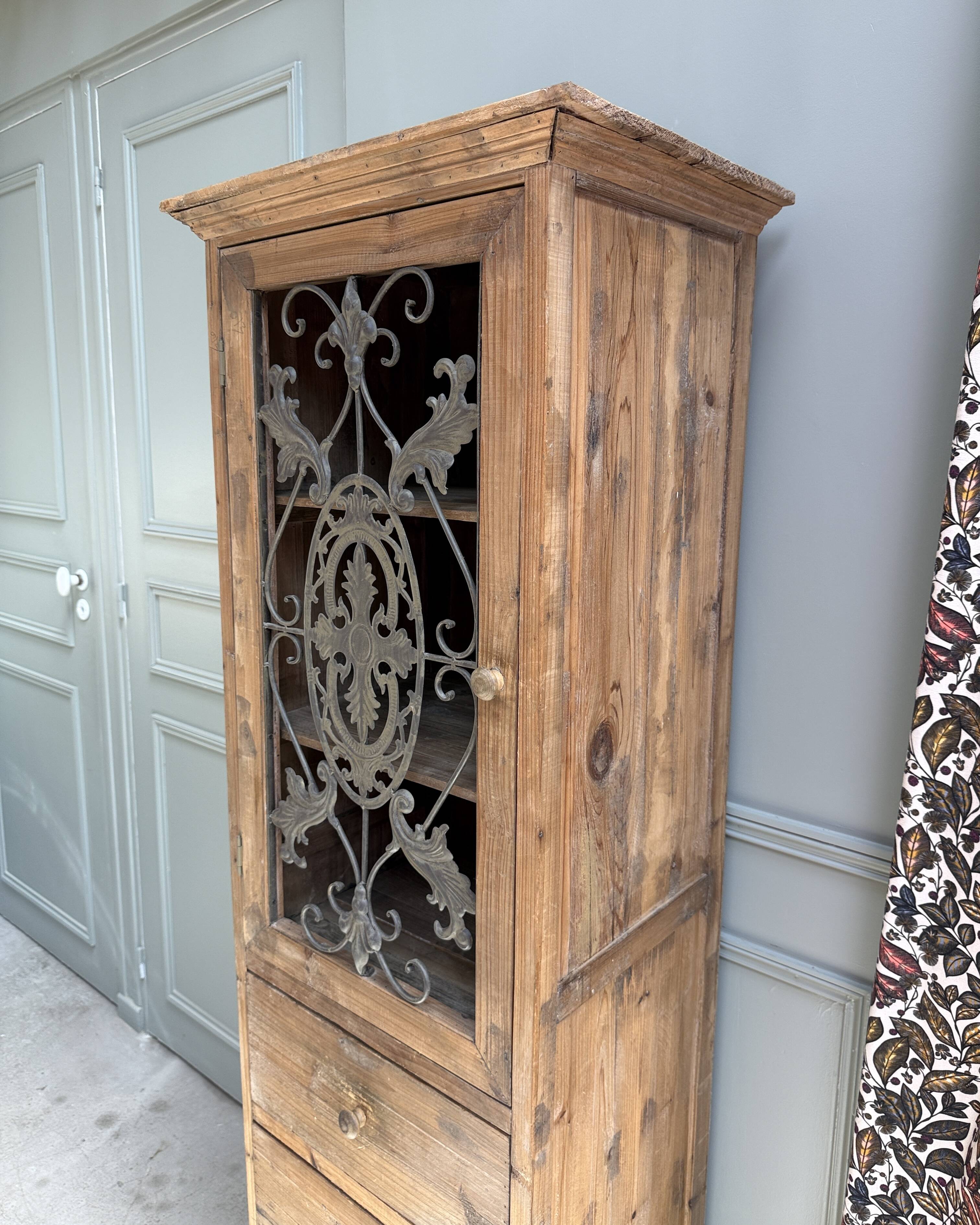 Column storage unit with a sculpted metal door.