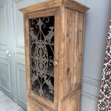 Column storage unit with a sculpted metal door.