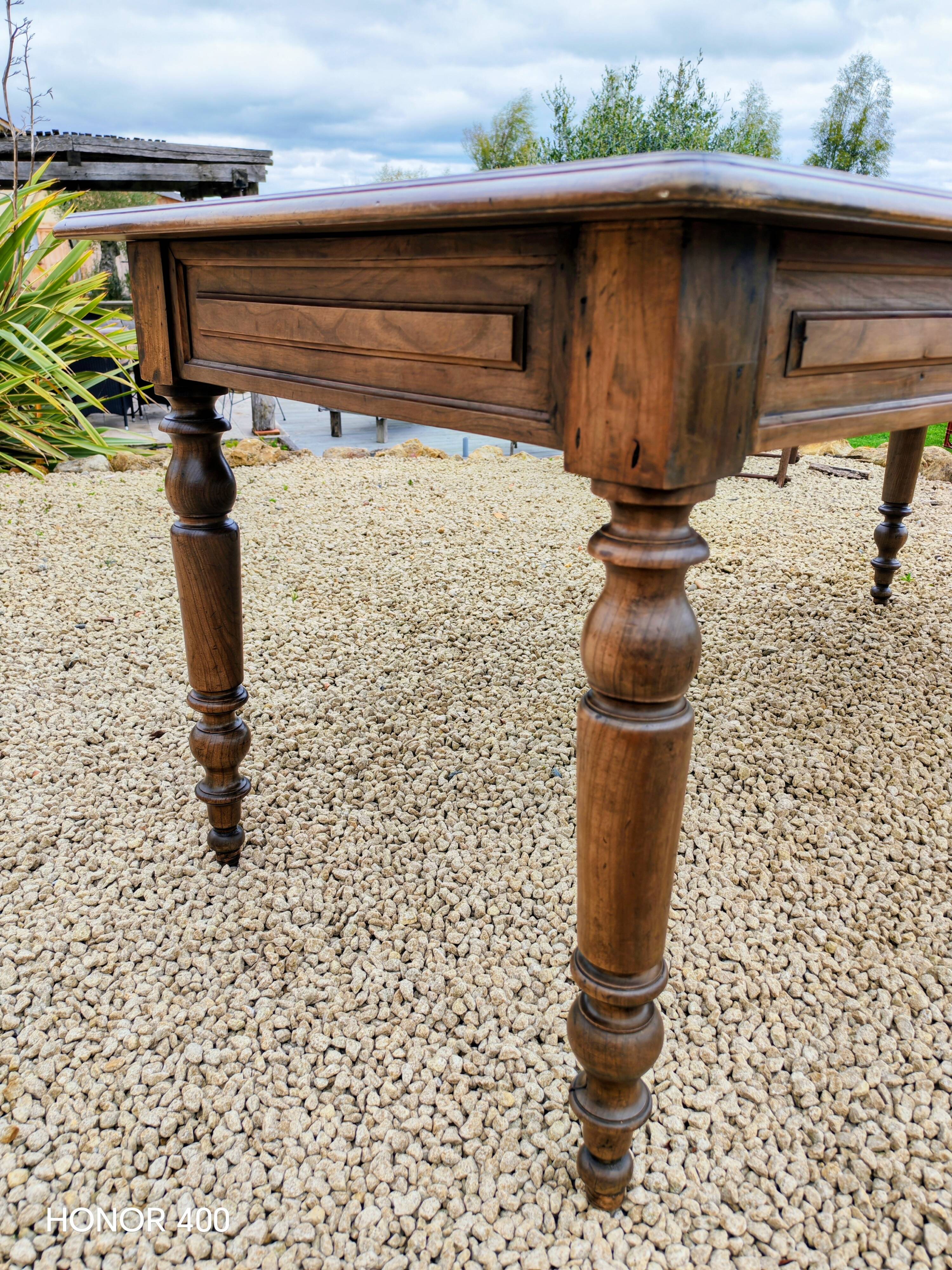 Old French farmhouse table in walnut with turned legs.