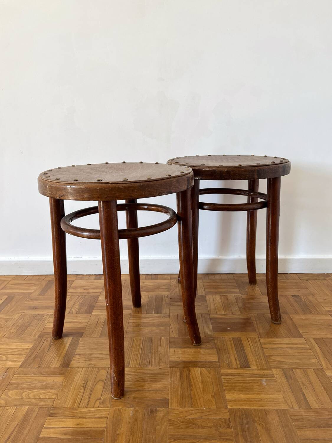 2 antique bistro stools with curved wood and caning effect.