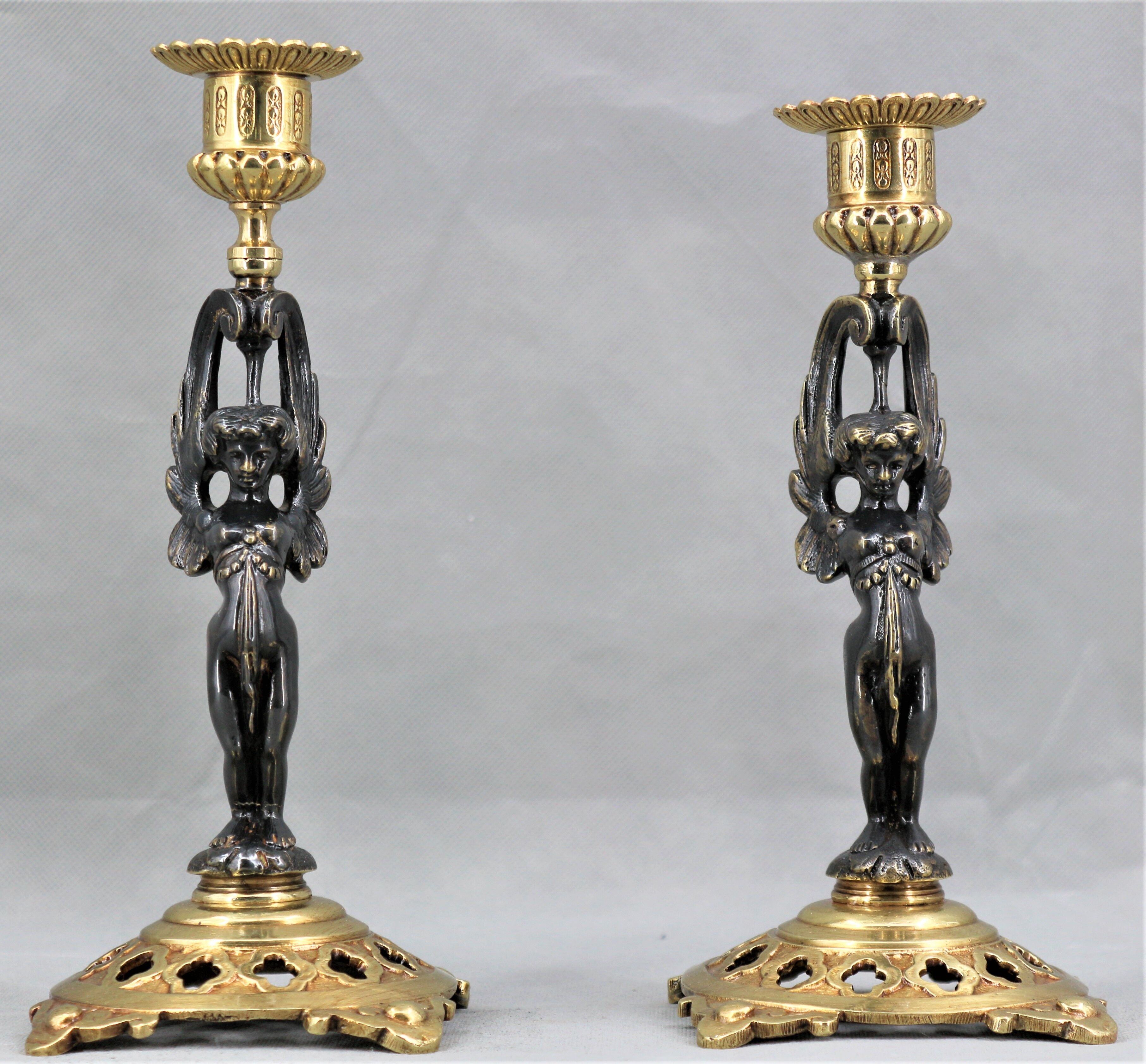 Pair of candle holders in gilded bronze and patinated with a candle