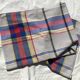Light grey rectangular tablecloth with blue, red, and yellow checks.