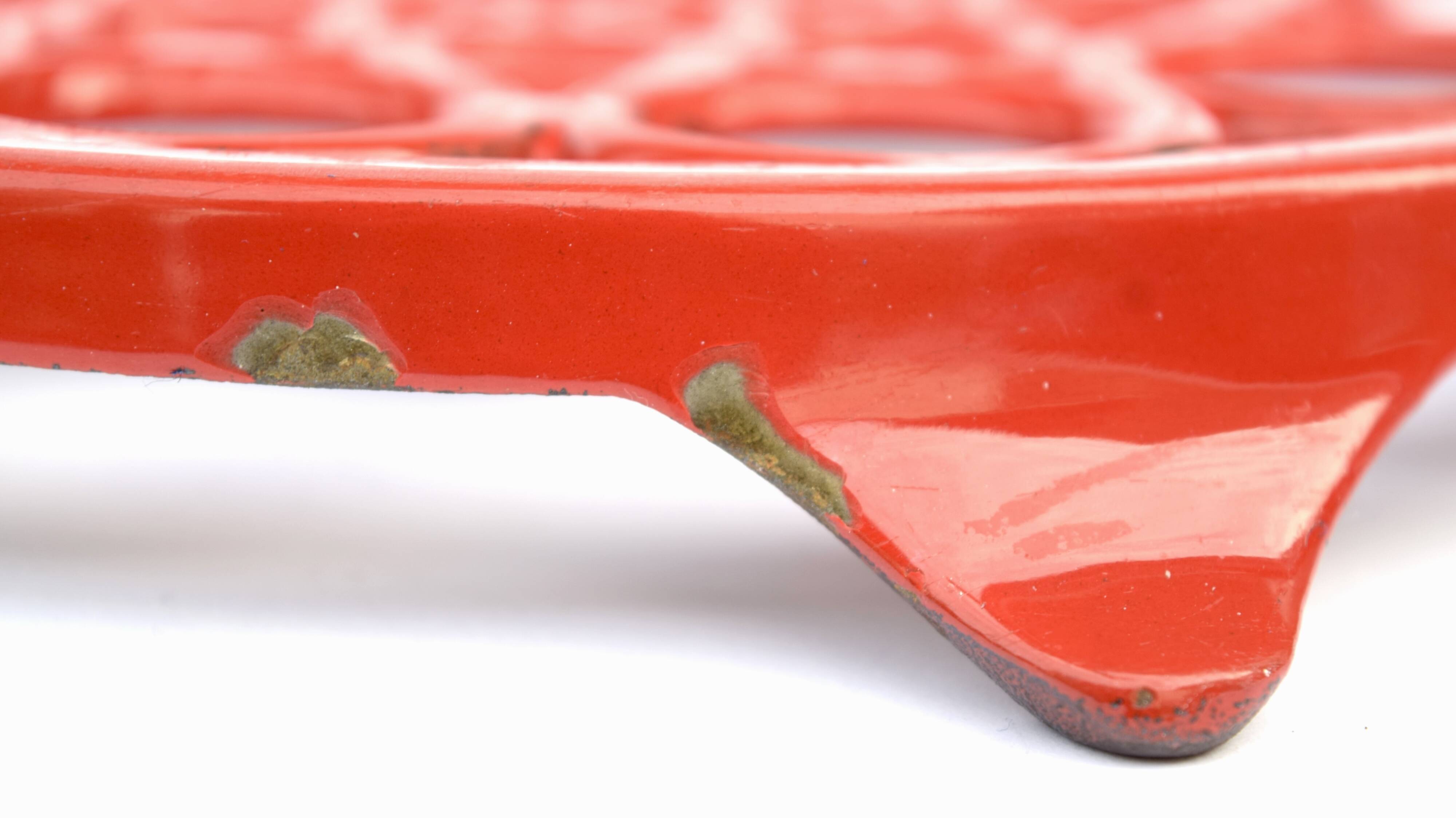 Vintage red enameled cast iron trivet