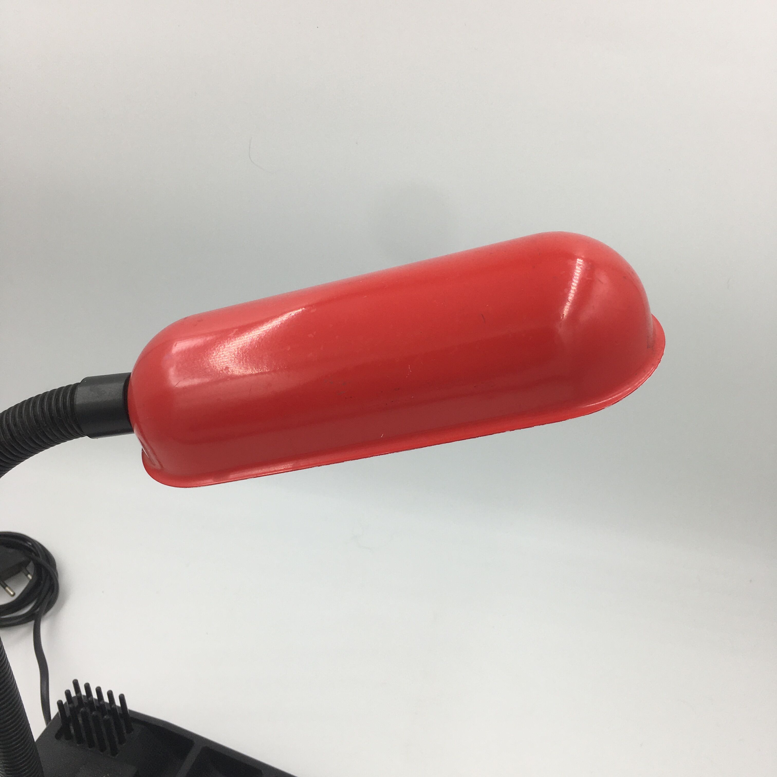 Duo of red and black flexible desk lamps with pencil holder
