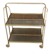 Vintage folding cart in gold brass and smoked plastic with two trays and wheels.