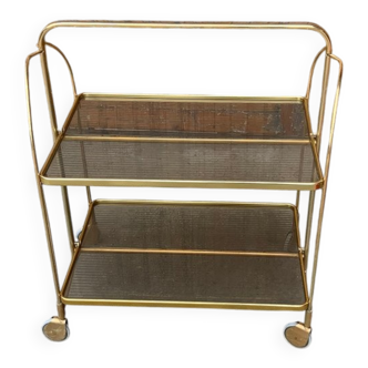 Vintage folding cart in gold brass and smoked plastic with two trays and wheels.