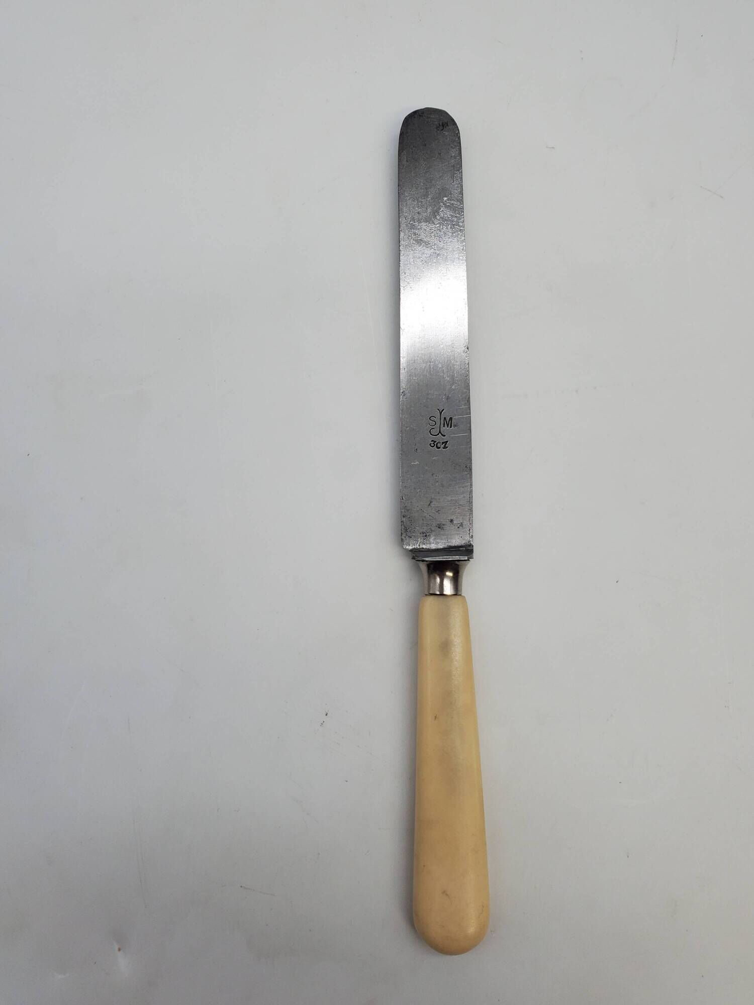 Set of 4 dessert knives with rounded blades and smooth ivory resin handles.