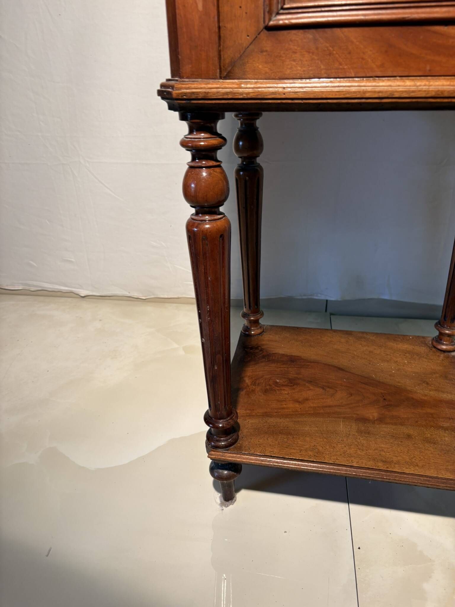 Antique wooden bedside table with turned legs.