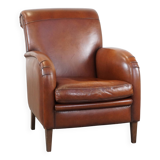 Cognac-colored sheepskin armchair with rounded shapes