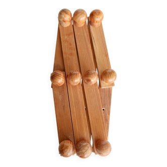 Antique wall-mounted coat rack accordion in dark pine, 10 wooden hooks.