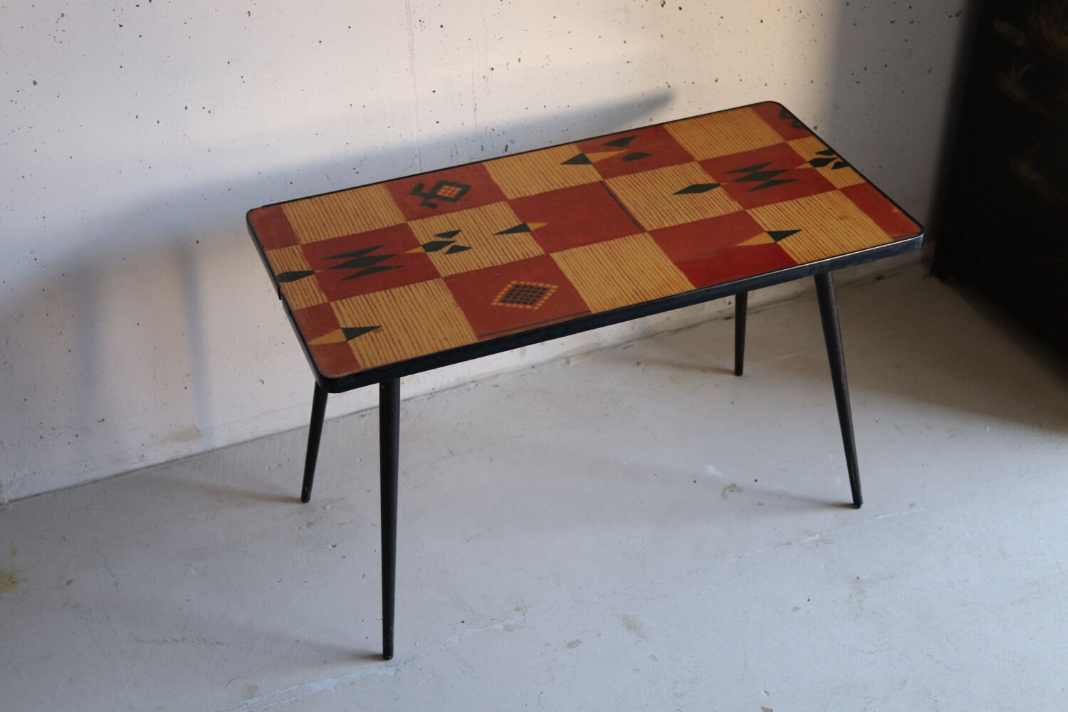 Vintage coffee table in laminate with geometric design, with tapered legs.