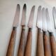 Old table knives and dessert knives, wooden handles, stainless steel blades
