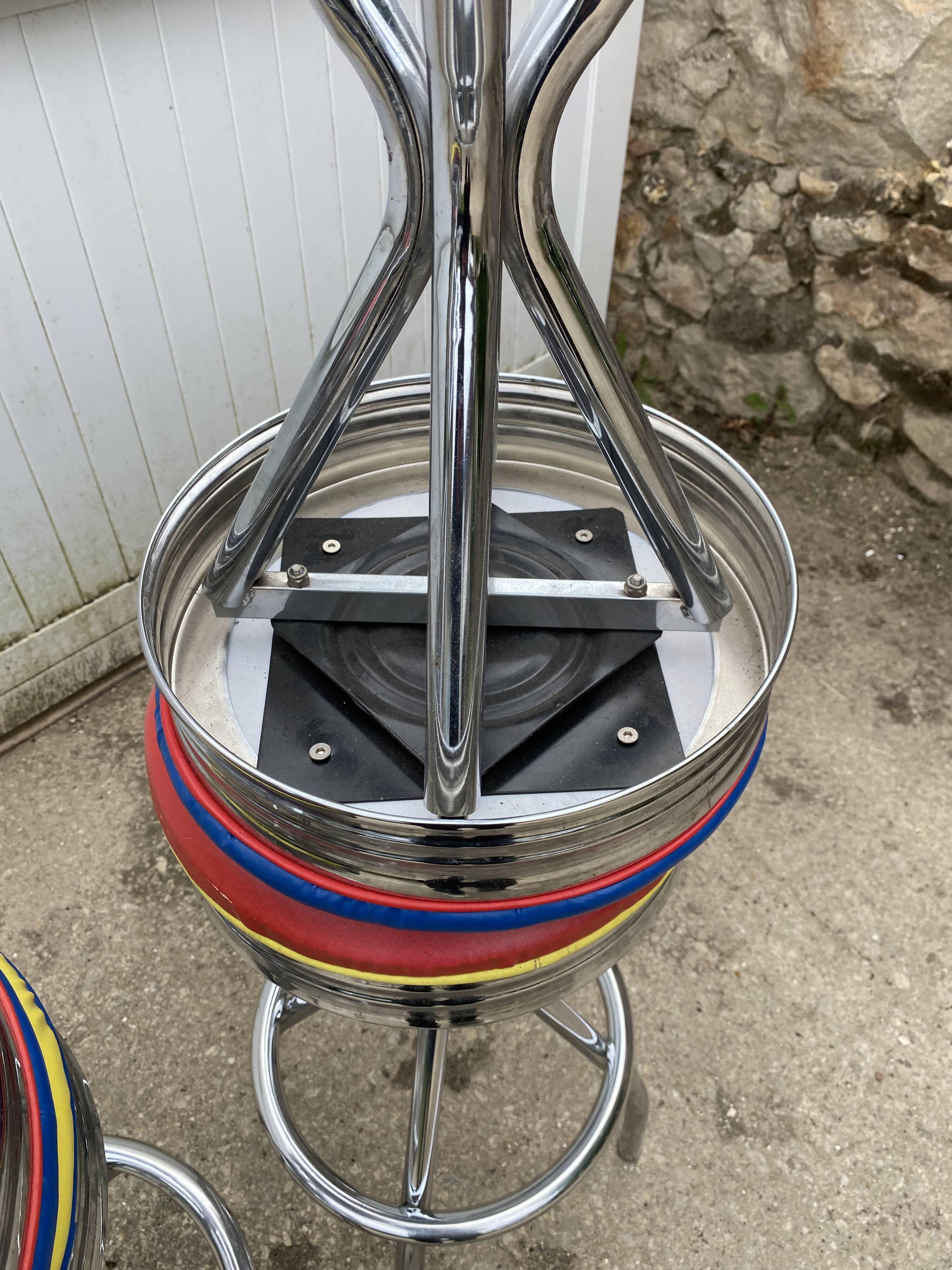 Set of 5 vintage swivel bar stools in blue, red, orange, and yellow.