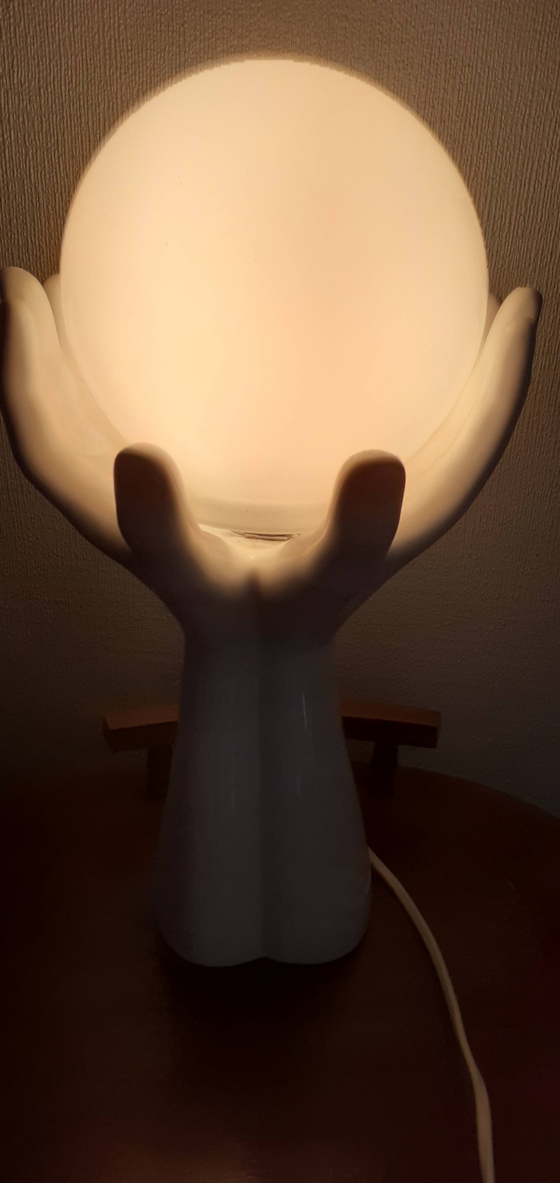70s lamp two hands embrace an opaline globe