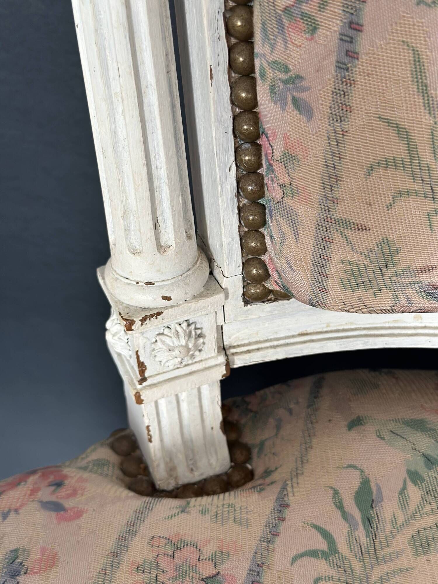 Antique Louis XVI style chair with patinated wood and floral fabric.