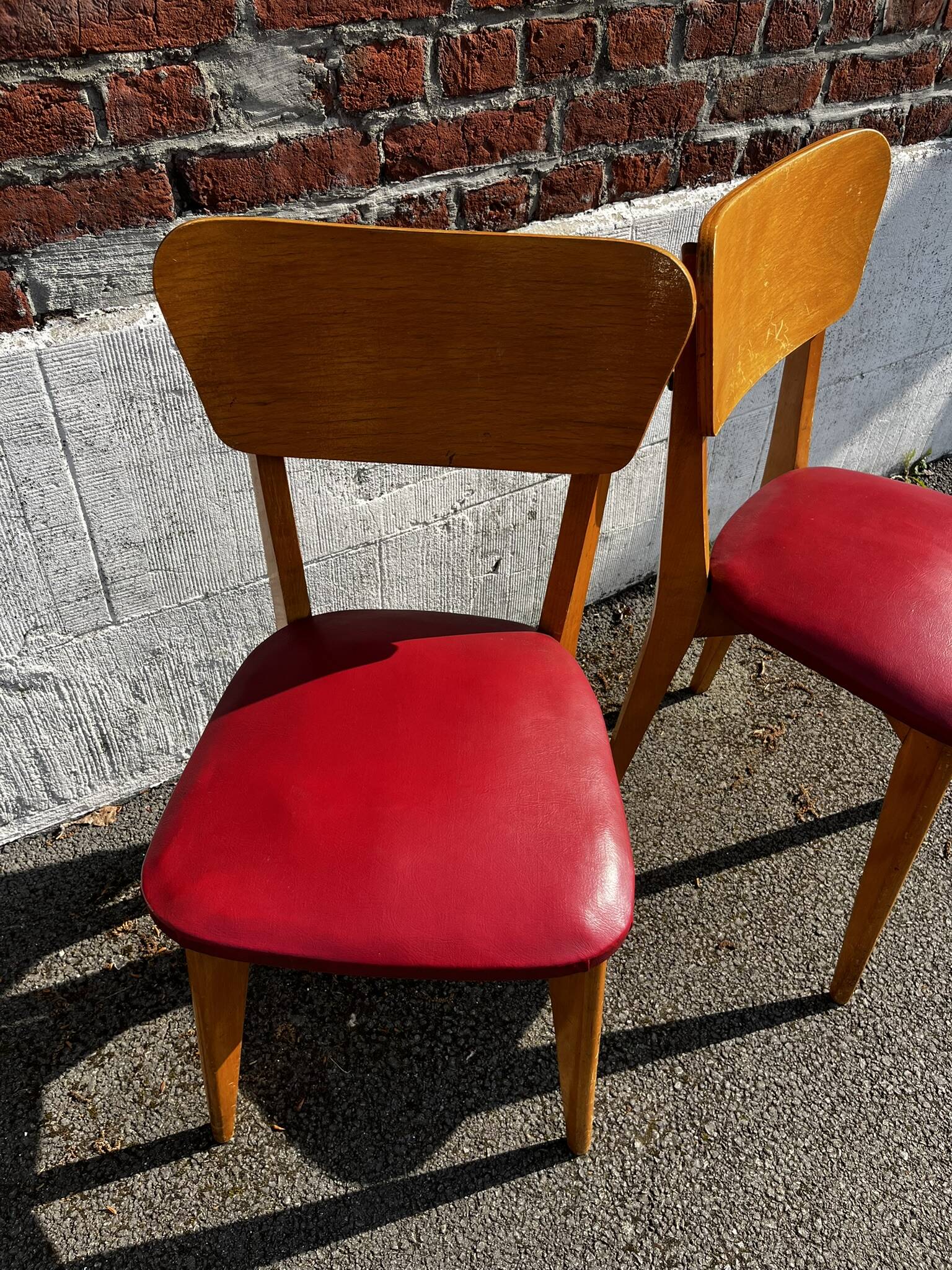 Set of 4 vintage bistro chairs in wood and red faux leather, with splayed legs.