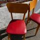 Set of 4 vintage bistro chairs in wood and red faux leather, with splayed legs.