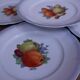 Set of 7 dessert plates and a cake stand with fruit patterns.