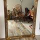 Large Deknudt mirror in gilded wood and glazing beads