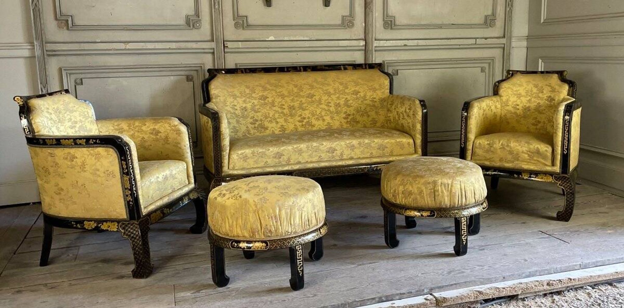A set of two armchairs, a sofa and two poufs in lacquered wood with gilded chinoiserie decoration.