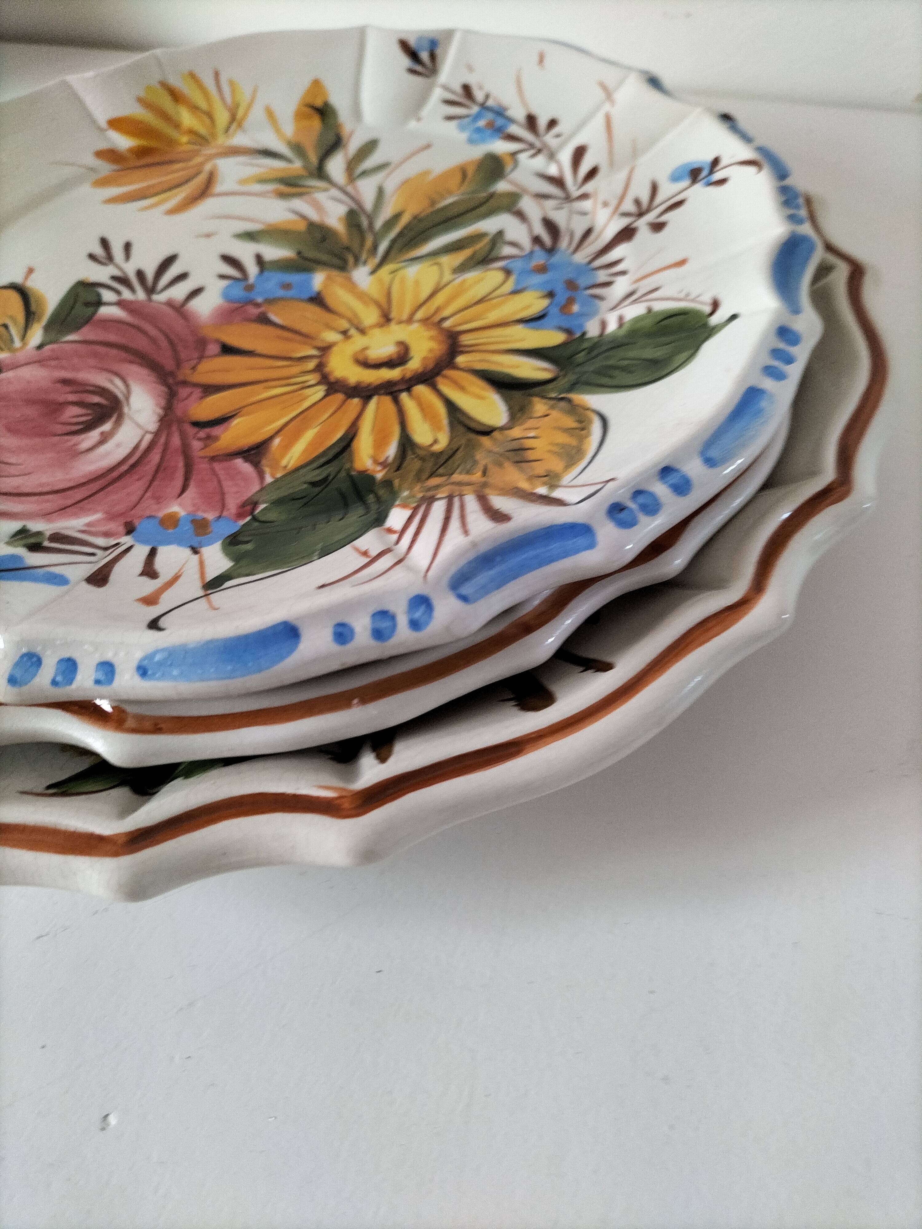 Set of three earthenware plates from Bassano, hand-painted with fruit and flower designs.