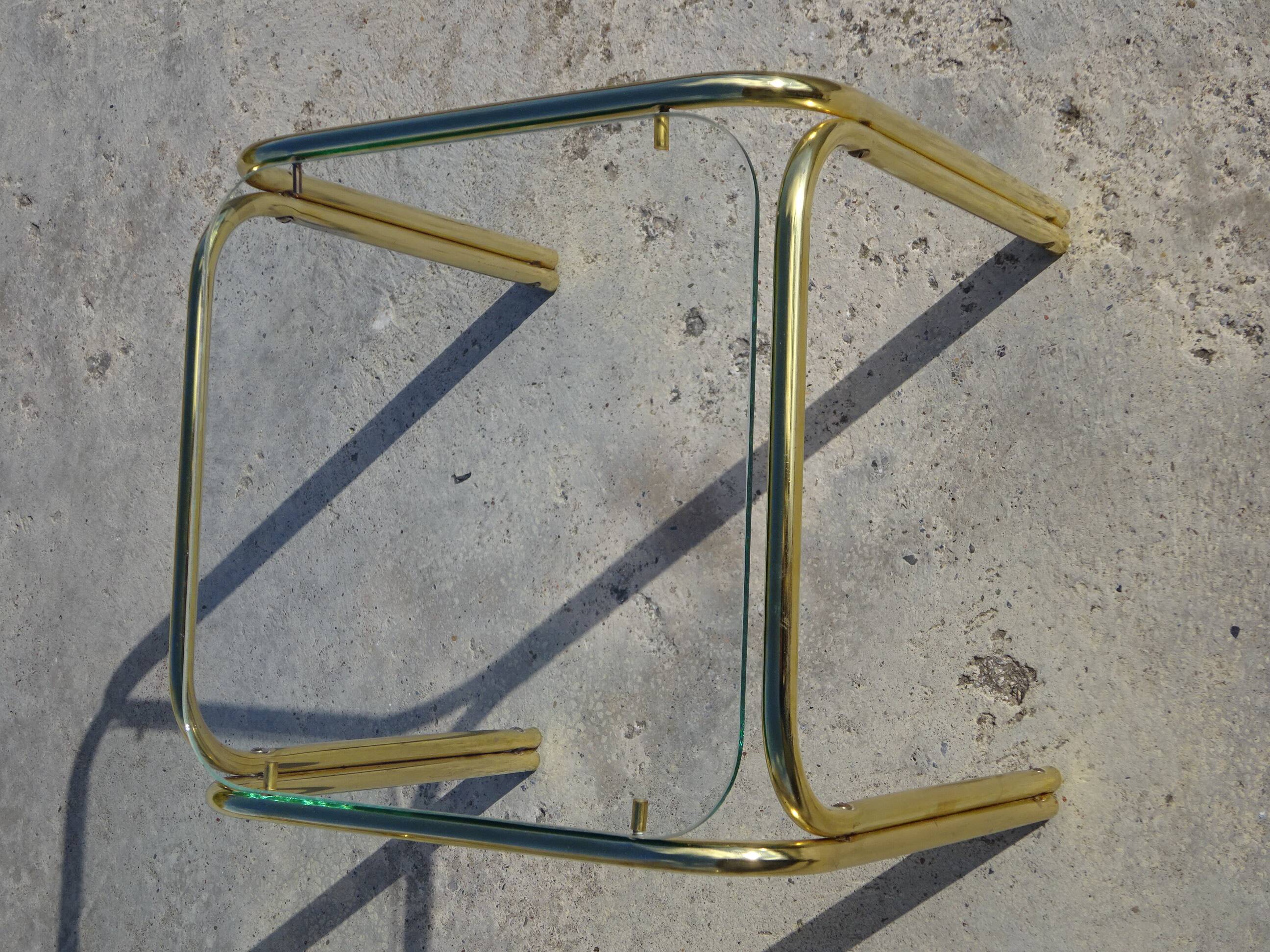 Nested tubular tables in gold metal.
