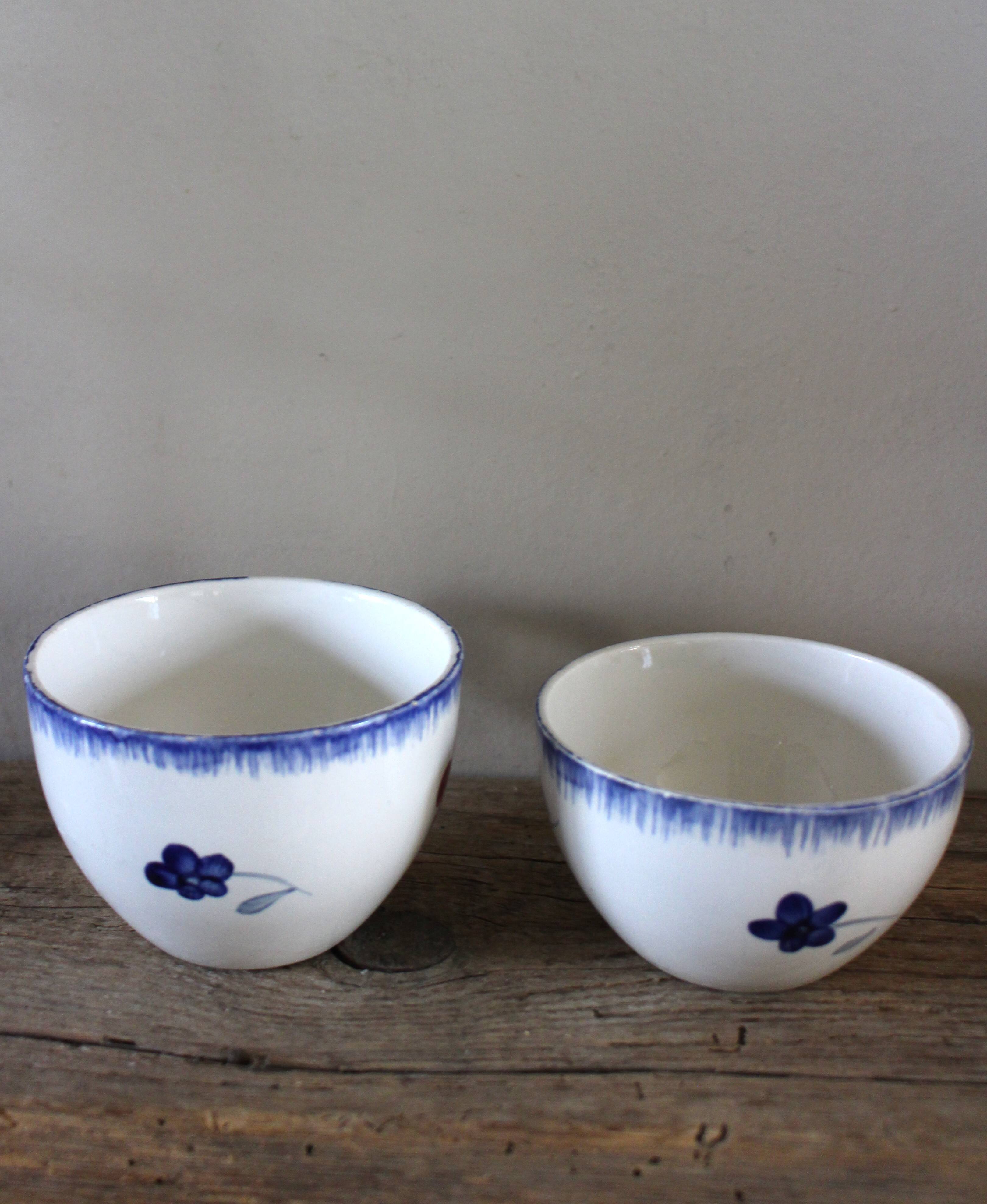 A set of two Digoin earthenware cups with blue, red, and yellow flowers.