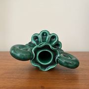 Green ceramic candlestick with curled handles.