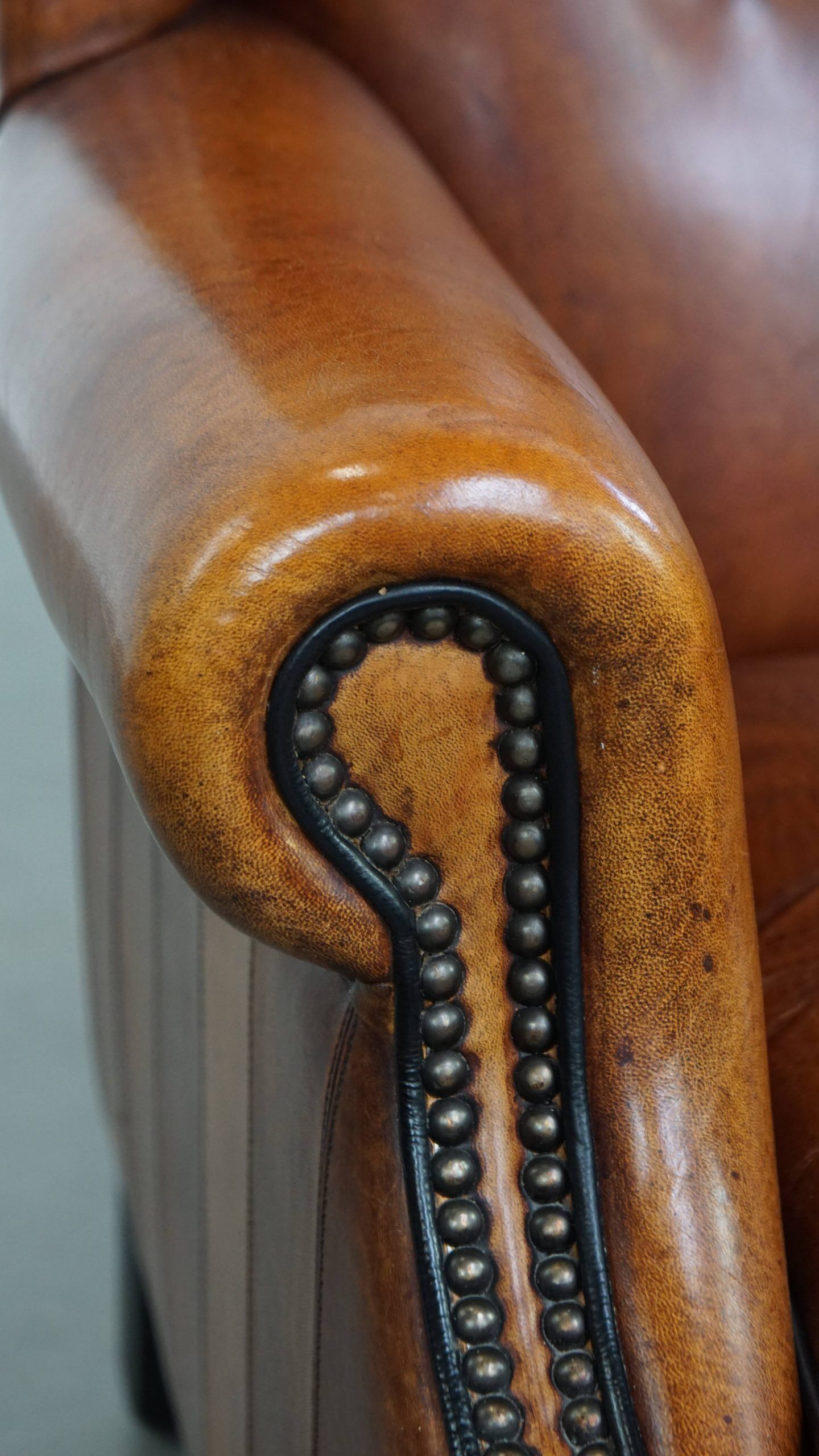 Sheepskin wingback armchair with stitching and black piping