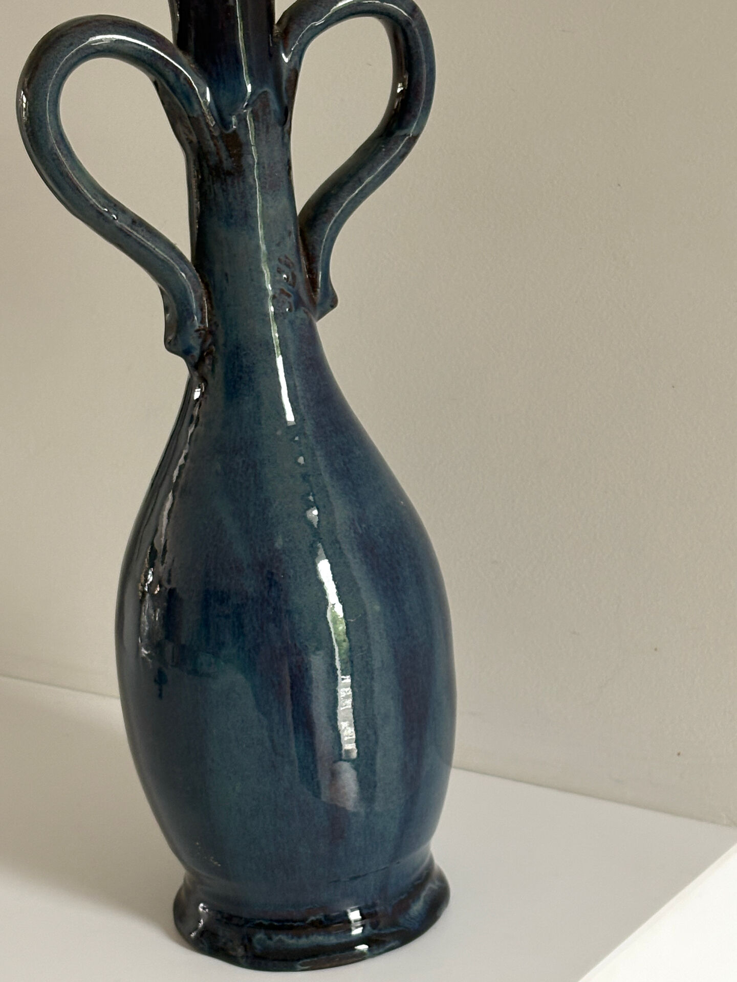 Decorative deep blue glazed ceramic vase with twin handles.