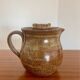 Large antique brown glazed stoneware jug with cork stopper.
