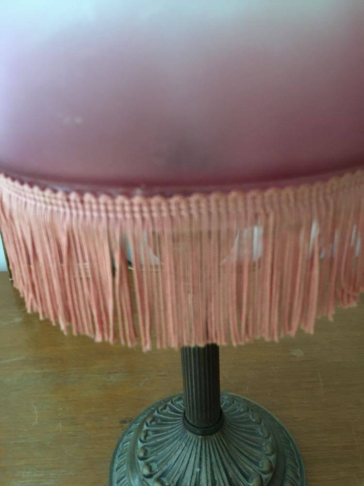 Old table/bedside lamp with glass shade with pink gradients and fringes.