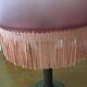 Old table/bedside lamp with glass shade with pink gradients and fringes.