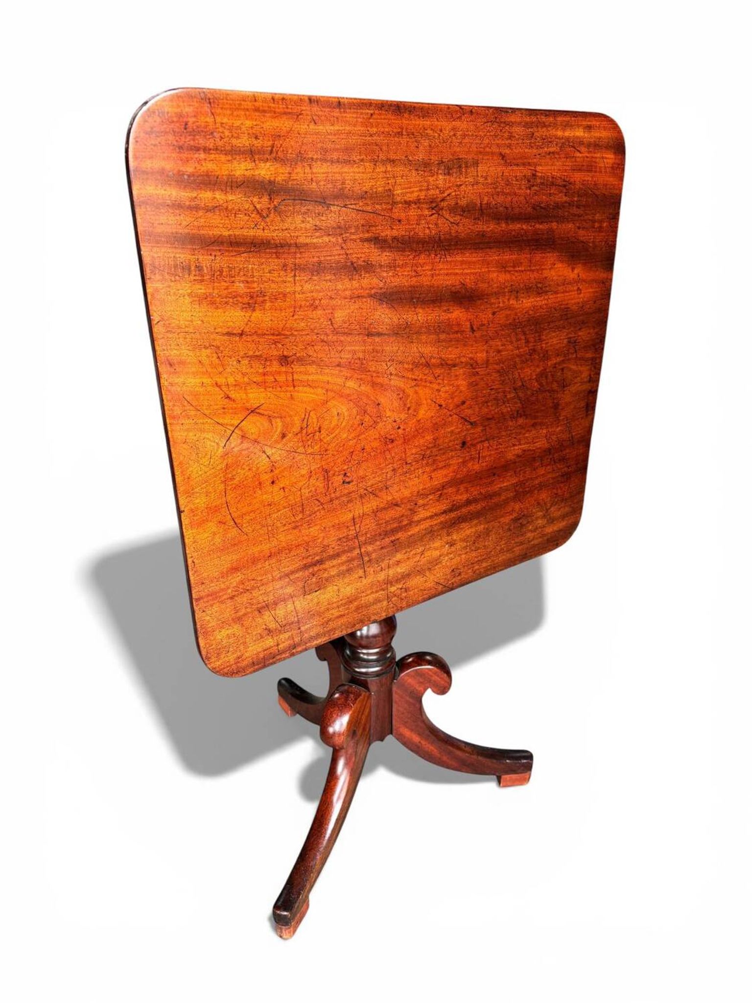 19th-century solid mahogany table with a tilting top and brass mechanism.