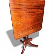 19th-century solid mahogany table with a tilting top and brass mechanism.